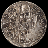 清代道光年台湾府铸库平七二“卍”字寿星银饼一枚，又称“台湾老公银”，币面多有行用时为验色而錾的戳记，此枚仅背面打有二处戳记，品相难得，极美品