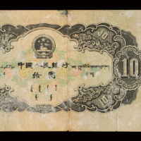1953年第二版人民币拾圆一枚，票左下冠字处一裂口，左边有蓝色笔记“29”，背部有胶，六五成新