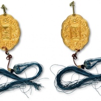  安南金佩“琼瑶永好”背“启定年造”牌饰一枚，重：17g，纯手工制作，四周以双凤、天书及火珠图案装饰，其中，启定年号使用为1916年至1925年。佩，于1889年开始颁发，专门用以奖赏具有高尚美德的女性