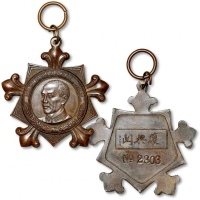  民国蒋介石像中央训练团毕业纪念章一枚，编号：2303，此章设计优美，工艺制作极为精良，蒋像肩下署“益谦谨刻”四字，为当时中央造币厂雕刻师董益谦刻模，此人头像也制作过几种样币，且极为罕见，此章少见，保存